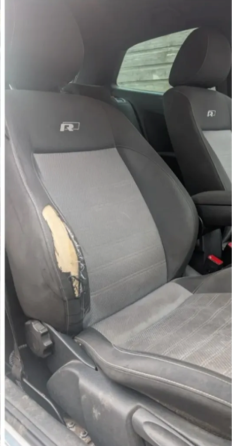 R sports seat before repair with exposed foam on the outer bolster