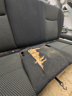 Fabric vehicle seat before repair with a badly torn centre panel